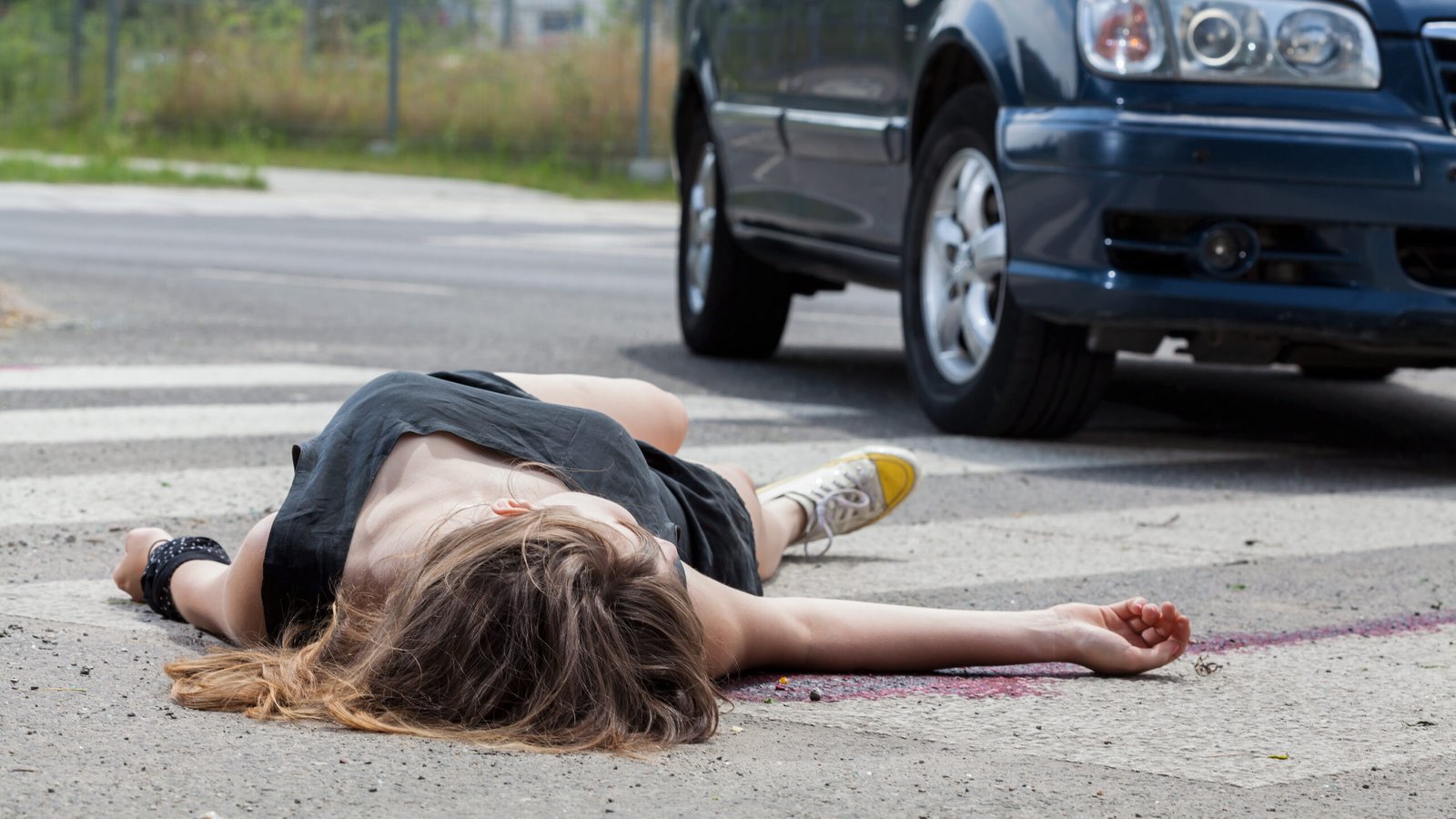 A woman lies on a crosswalk after being struck by a car, emphasizing the dangers pedestrians face on Colorado Blvd in Pasadena.