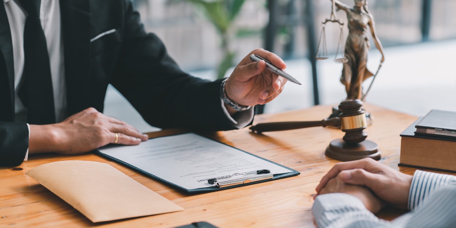 A lawyer discussing with a client and showing them a document, emphasizing the importance of reviewing insurance policies and understanding the insurance liability limits during legal consultations.