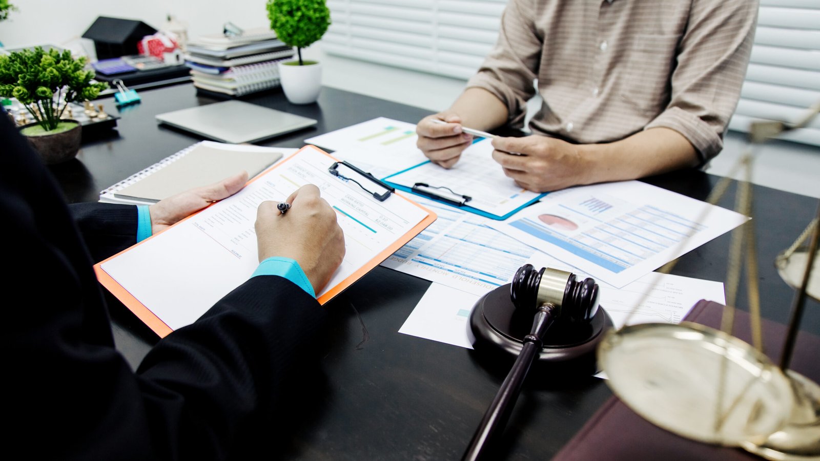 Two individuals sitting at a desk, discussing personal injury details and documents during an initial consultation.