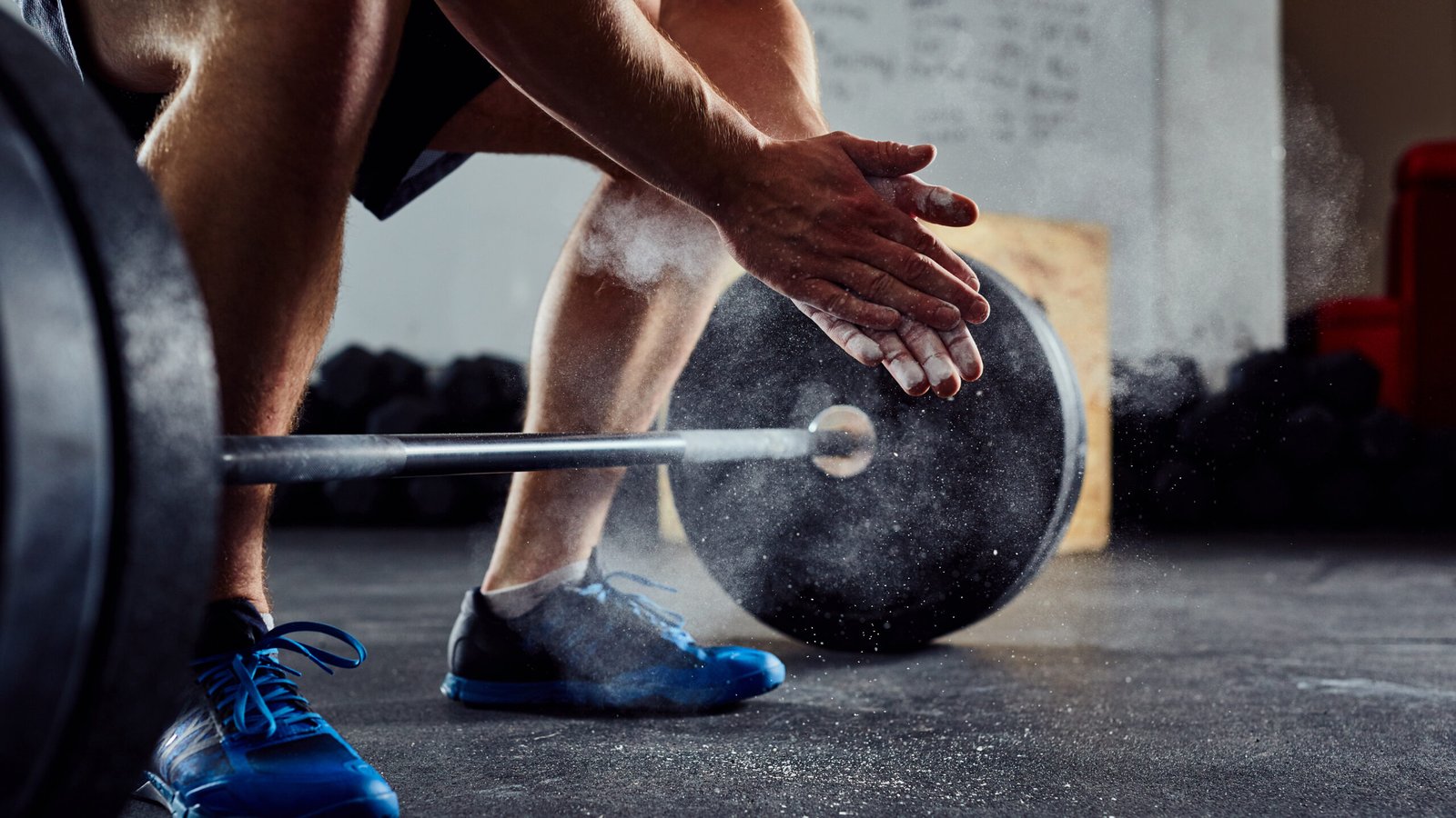 Close-up of a personal injury attorney chalking his hands before a heavy lift in the gym, representing the strength and dedication he brings to every client case.