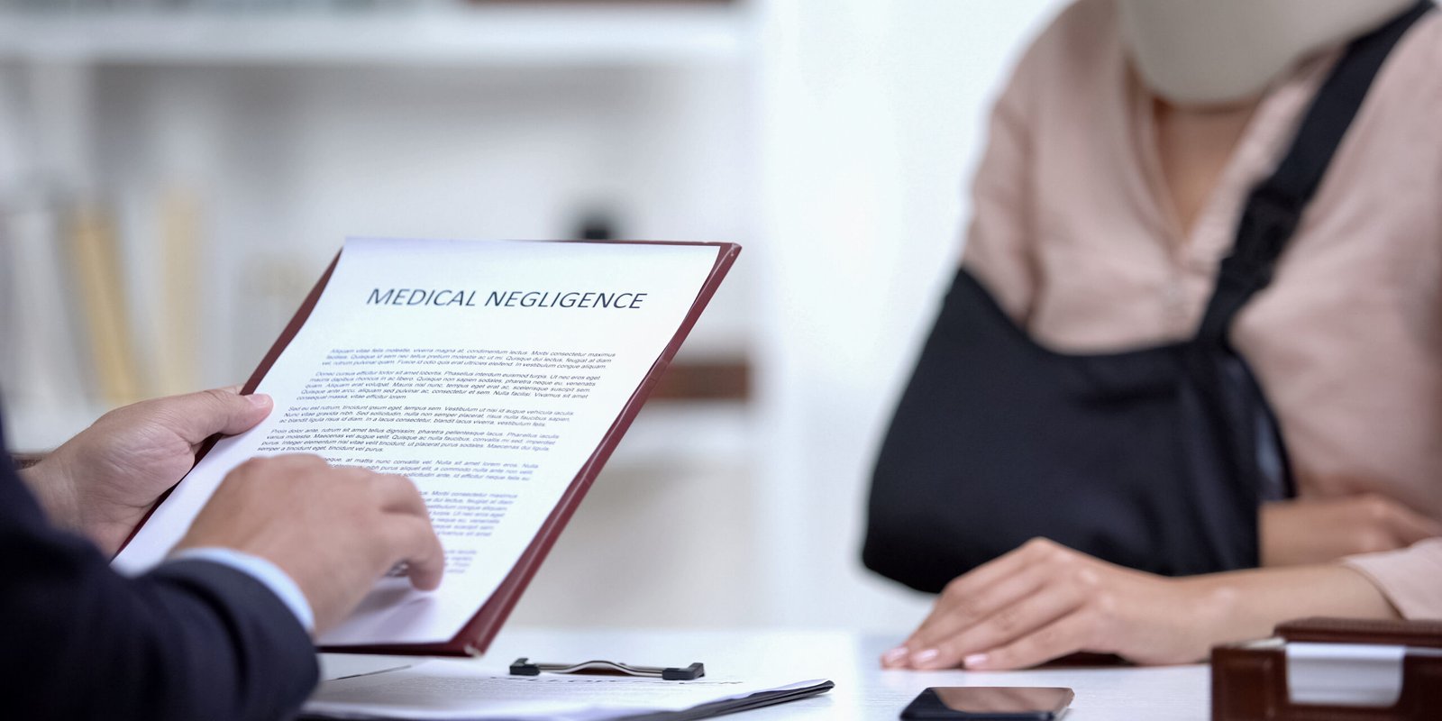 A personal injury attorney explains a medical negligence case to an injured client in a neck brace, showing commitment to supporting clients throughout their recovery.
