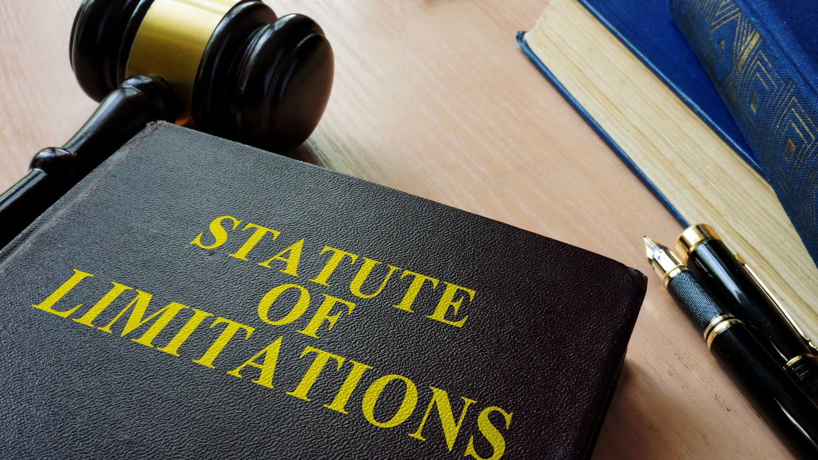A law book titled "Statute of Limitations" beside a gavel and fountain pen, highlighting the importance for personal injury attorneys and clients to know legal deadlines for filing claims.