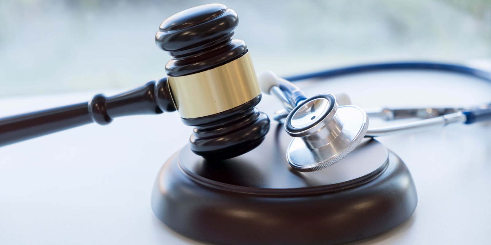 Wooden gavel resting beside a stethoscope, representing the connection between medical care and navigating personal injury law cases.